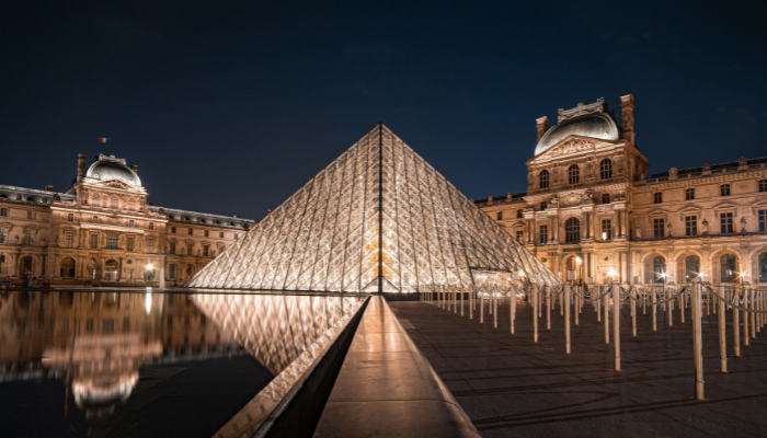 Louvre Pyramid illuminated at night in the courtyard of the Louvre Museum in Paris