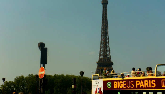 Big Bus Paris sightseeing bus passing the Eiffel Tower in Paris
