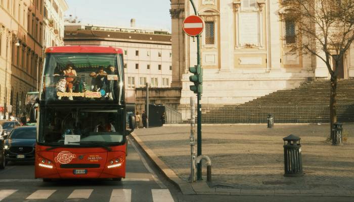 City Sightseeing Rome red double-decker bus passing historic buildings in Rome