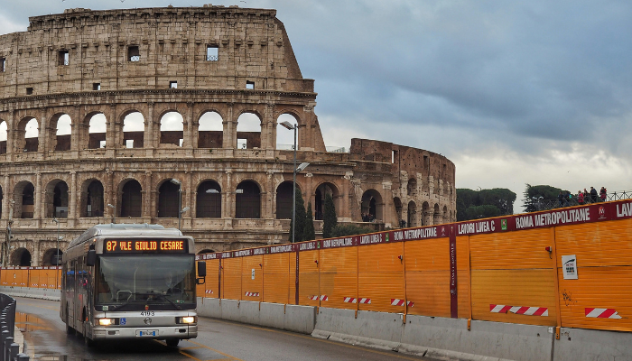 Public bus travelling along a cobbled street near Rome’s historic landmarks