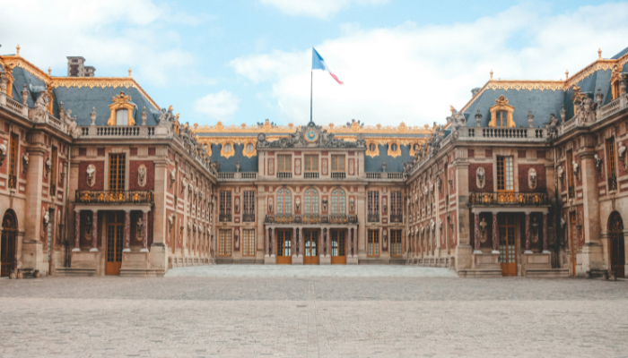 Palace of Versailles with its ornate golden façade and central courtyard